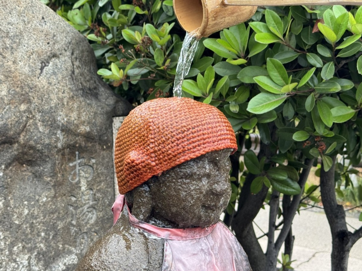 松江市千鳥町にある『お湯かけ地蔵尊』にお湯をかけているところ