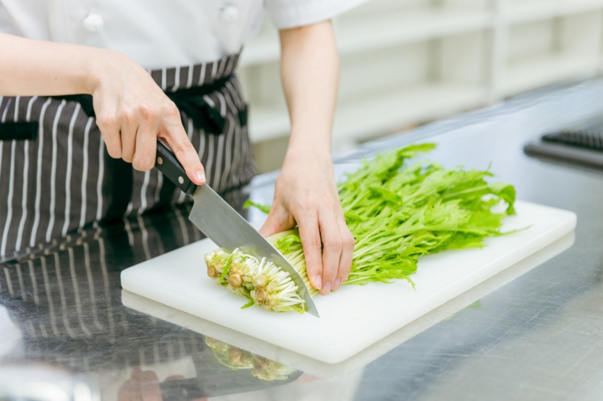 まな板の上で野菜を切る女性