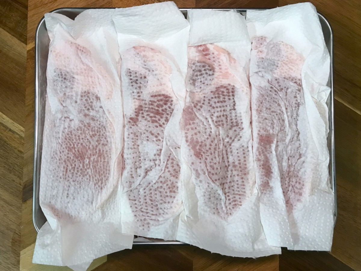 豚肉の水分をキッチンペーパーで吸い取っているところ