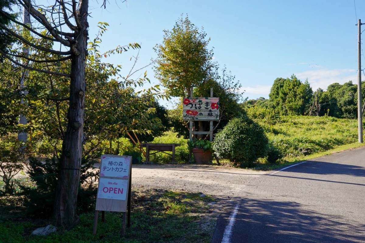椿の森へ入る道路沿いに設置された、森とカフェの案内看板