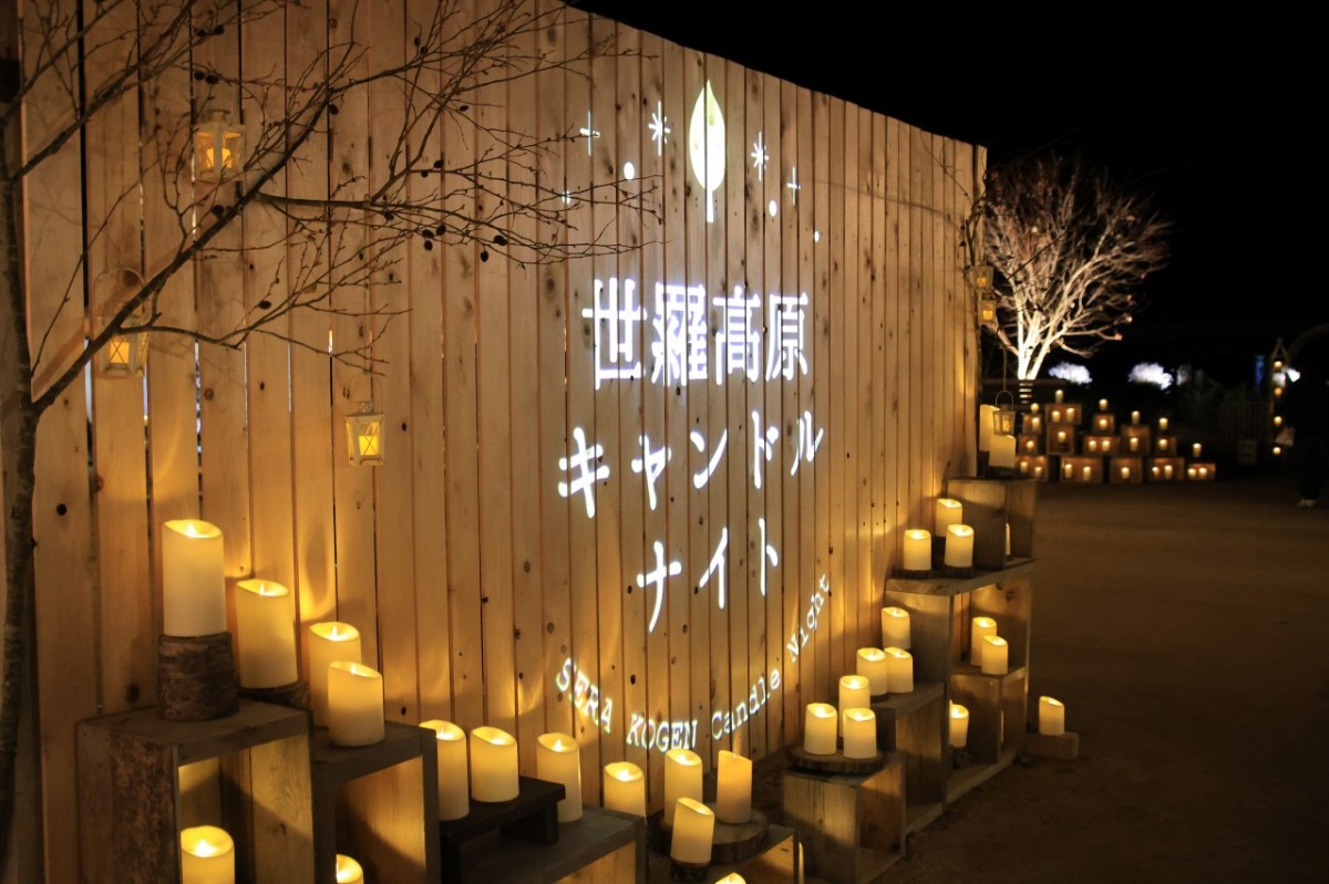 広島県世羅町の世羅高原キャンドルナイトで、イベント名が書かれた看板と周囲を彩るキャンドル